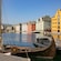 A Viking longship moored at the harbor with buildings lining the waterfront